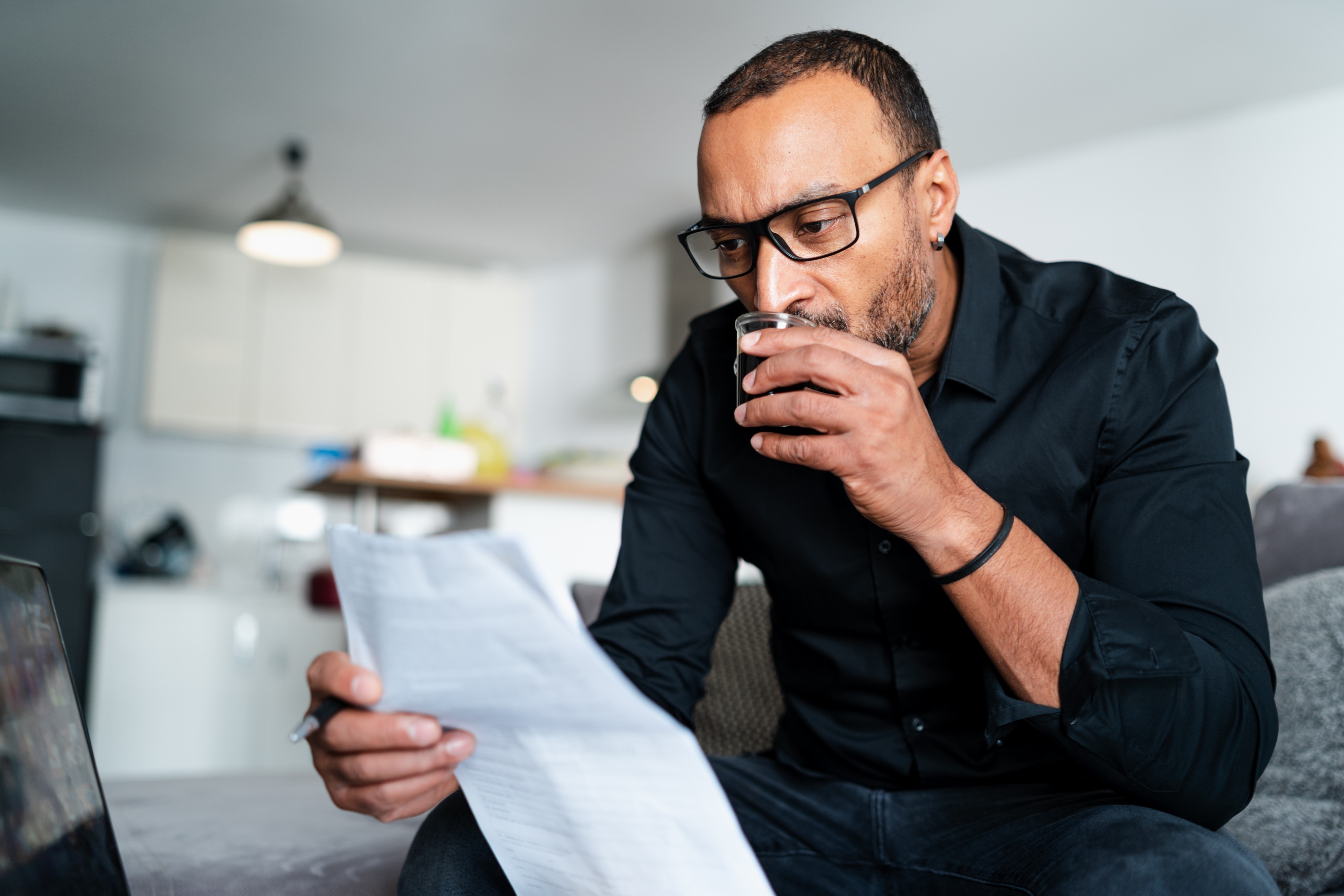 Man Reads A Document Wearing Glasses